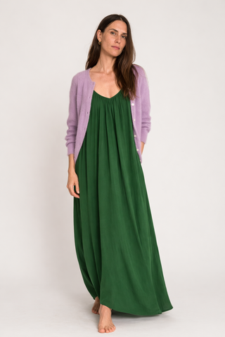 Model trägt das Justine Kleid in Grün und daürber einen fliederfarbenen Cardigan.