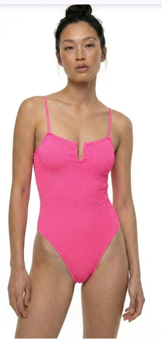 Model trögt ein Badeanzug der griechischen Marke SORBET ISLAND in der coolen neon Farbe Neon Strawberry.