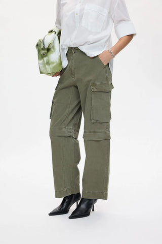 die cargopants in der farbe sage von der marke Raben Saloner sind weit geschnitten und haben zwei grosse Hosentaschen auf der seite. 