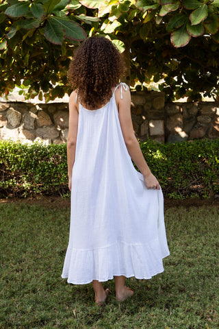Ein leichtes Sommerkleid aus weichem Baumwoll-Musselin (Double Gauze) in reinem Weiss. ALIX besticht durch seine fliessende A-Linien-Silhouette, schmale Bindeträger und einen sanft ausgestellten Volantsaum. Die zweilagige Musselin-Qualität sorgt für angenehme Leichtigkeit und ein natürliches Hautgefühl. Ideal für Strandtage, Sommerreisen und moderne, luftige Alltagslooks. Einheitsgrösse, für verschiedene Körperformen geeignet.