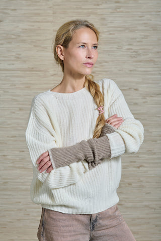 Model Sandra trägt den weissen Kaschmirpulli RIBAN der Schweizer Marke AYRE. Ein rundhals Pullover, nicht genäht, nur gestrickt, hergestellt in Italien. Der Pulli hat ein geripptes Muster.
