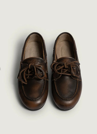 Man sieht einen dunkelbraunen Boat Loafer im klassischen Stil. 
