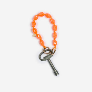 bonbon keychain der marke ayre in orange mit einem alten schlüssel