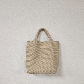 Die Cabane Tasche, eine aus Neopren geflochtene Handtasche der Schweizer Marke AYRE, hier in der Farbe Powder, ein sehr helles beige.