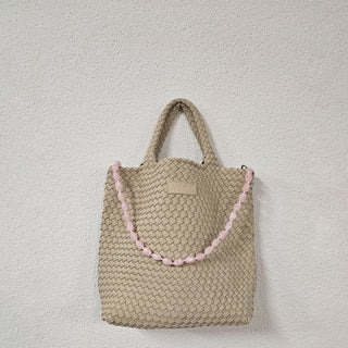 Man sieht die Neopren Tasche CABANE, der Schweizer Marke AYRE. Hier zu sehen mit einer Handykette Bonbon in pink, ebenfalls von der Schweizer Marke AYRE.