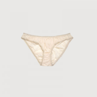 man sieht eine altmodische süsse unterhose aus cream farbiger baumwolle mit einem beigen spitzensaum