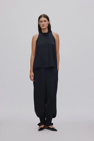 Model trägt die schwarze Dalvina Hose von Rabens Salone und das passende ärmellose Top dazu. Eine elegante Hose mit der Möglichkeit durch ein Band unten am Saum die Hose zusammen zu nehmen.