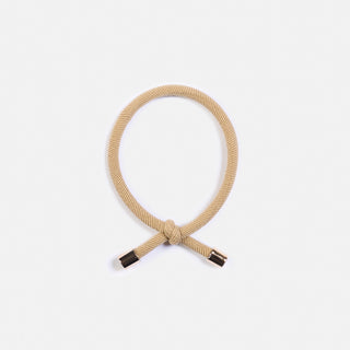 Man sieht eine Nahaufnahme des Haargummi Flip der Schweizer Marke AYRE. Ein Haargummi mit einem Knoten welcher dem Haargummi eine stylische Note gibt. 