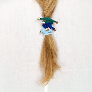 Man sieht einen Haarzopf mit drei Haargummis drin, das Flip Haargummi der Schweizer Marke AYRE, in den Farben green, royalblue und skyblue.