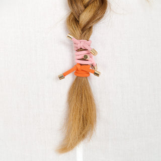 Man sieht einen Haarzopf mit drei Haargummis FLIP der Schweizer Marke AYRE.