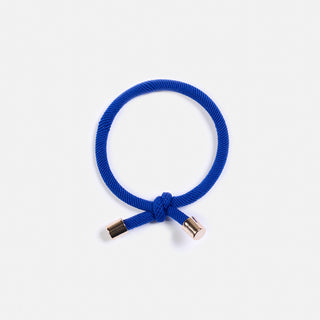 knallblaues Haargummi mit einem schönen Knopf und goldenen Details. Von der Schweizer Marke AYRE.