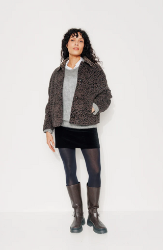 Model trägt die Galana Jacke der Marke Trench & Coat aus Frankreich, Sie hat ein schönes feiner Leopardenmuster. Ist kurz geschnitten und hat einen Kragen und vier Knöpfe vorne zum verschliessen.