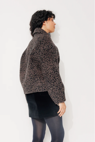 Model trägt die Galana Jacke der Marke Trench & Coat aus Frankreich, Man sieht das Model in die Jacke von der Seite. Moderner boxy Schnitte, eher kurz und modern geschnitten. 