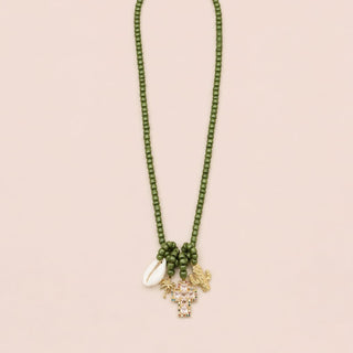 Halskette mit Kaktus, einem rosa goldenen Kreuz, einer goldenen Palme und einer Muschel als Anhänger.