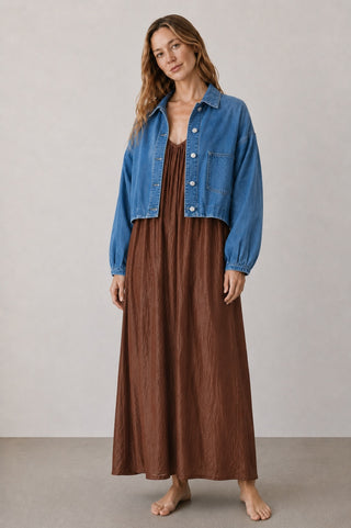 Model im mocca farbenen Lexane Kleid von AYRE aus der Schweiz, und der Herosa Jeans Jacke der Marke Elias Rumelis.