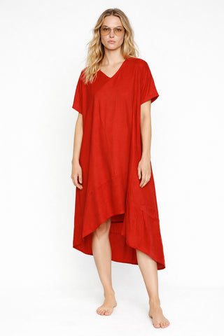 Rotes Sommerkleid der schweizer Marke AYRE. Vorne ist es kürzer als hinten. Das Model ist blond mit langen lockigen Haaren