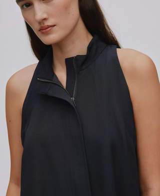 Man sieht eine detaillierte Aufnahme des KALEY Top der dänischen Marke Rabens Saloner. Das schwarze Top hat keine Ärmel, einen Stehkragen und einen Reissverschluss der in der Front vom Kragen bis zum Bund runter geht.