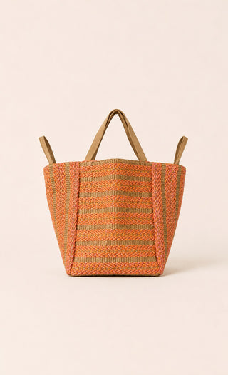 Seitliches Bild der Lamar Tasche der schweizer Marke AYRE. Eine grosse Strohtasche mit einem Geflecht aus rosa und orangen Baumwollstreifen.