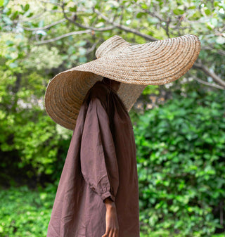 model traegt einen grossen tollen strohhut und das braune lynne kleid in brown von ayre