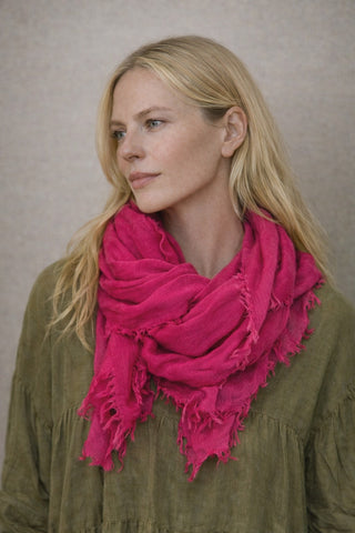 Model trägt den MALIN Schal in der Farbe pink. Zusammen mit dem MAUDE Kleid in olive, beides von der schweizer Marke AYRE. 