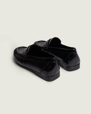 ein eleganter Penny loafer mit shiney Letter in der Farbe schwarz von hinten