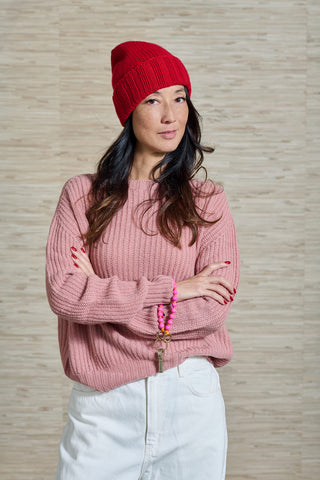 Model trägt den Riban Pulli, ein feiner rippstrick Kaschmirpulli der Schweizer Marke AYRE. Ebenso eine rote Kaschmirmütze der Schweizer Marke AYRE.