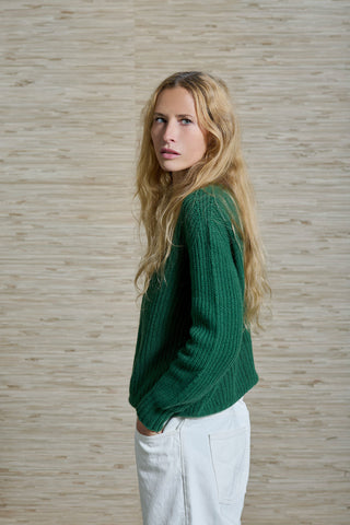 Model Sandra Jahn trägt den RIBANE Kaschmir Pulli der schweizer Marke AYRE. Ein gerippter Strickpulli in einem starken Grün. 