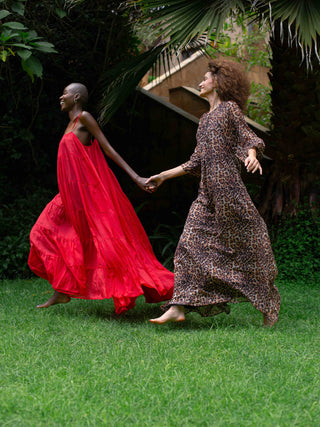 zwei models rennen im garten mit schoenen weiten kleidern von ayre