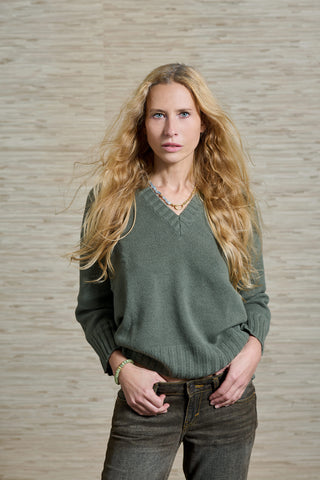 Model Sandra trägt den militärgrün farbenen Kaschmir Pulli Vince, aus 100% Kaschmir. Der Pulli hat einen klassischen V-Ausschnitt und ist von der Schweizer Marke AYRE. 