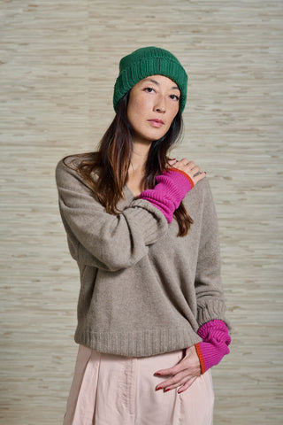 Model Vivienne trägt den VINCE Kaschmir Pullover in der Farbe brown, der Schweizer Marke AYRE. Zusammen mit pink/orangen Handstulpen und einer grünen Kaschmirmütze, ebenfalls beides von der Marke AYRE.